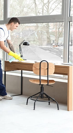 Ein Mann, der einen Tisch putzt – Reinigungsfirma in Hamburg